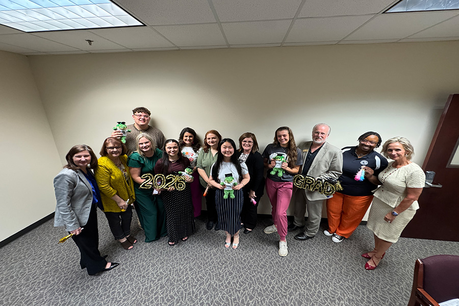 staff photographed with 4 spring 2026 graduates