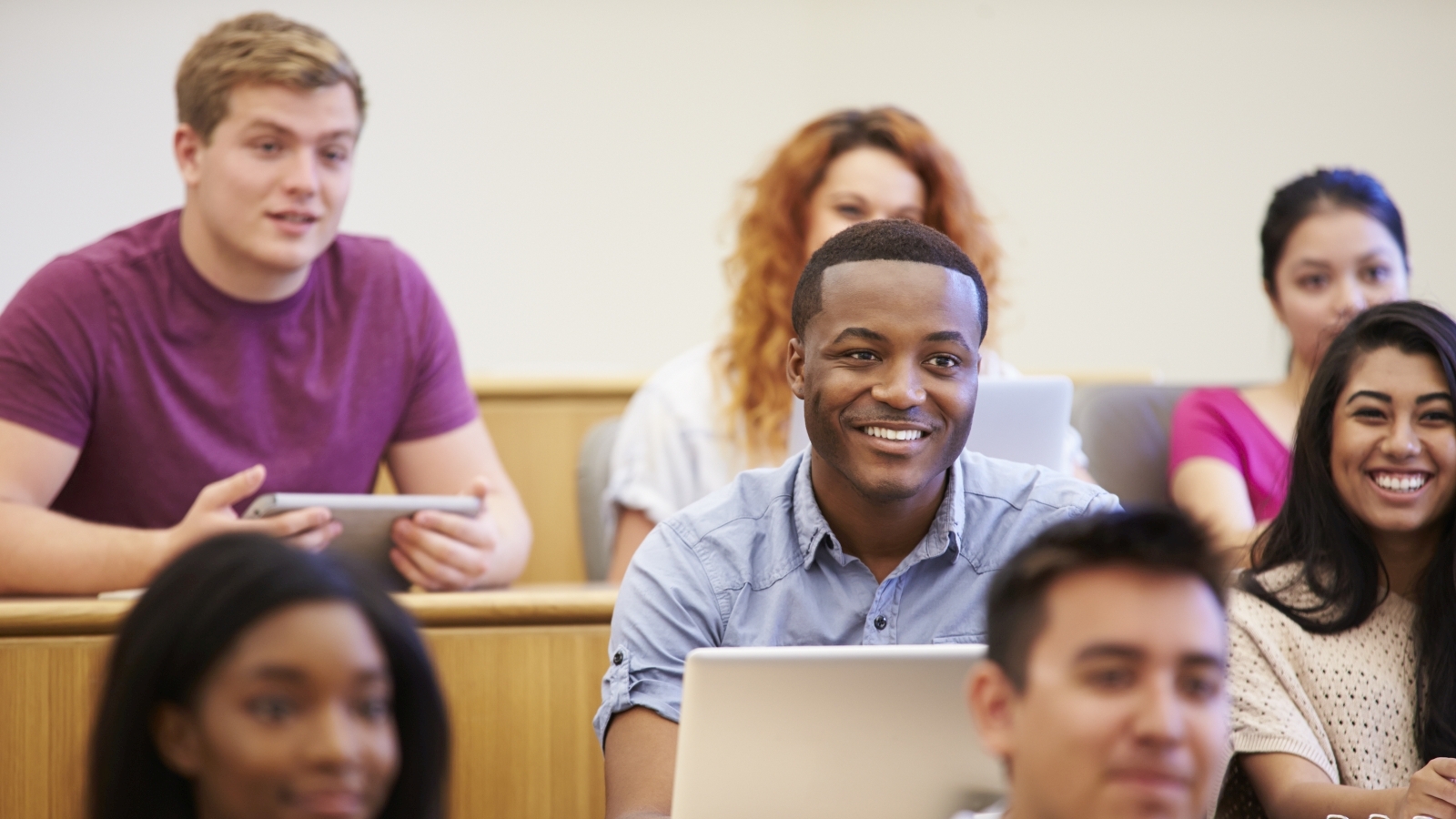 Students sit in a lecture-hall style classroom